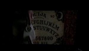 A young Debbie and Laine play with the Ouija Board as they believe its just a game. Little does Laine know that the Ouija board will lead her friend to death. Photo is screenshot.
